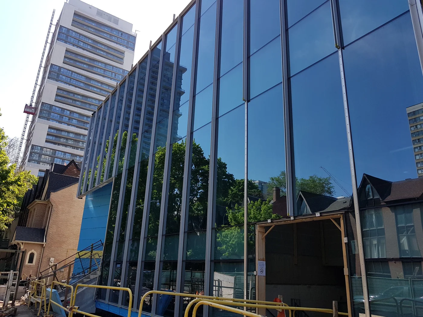 Reflective curtain wall facade with projecting vertical fins during construction